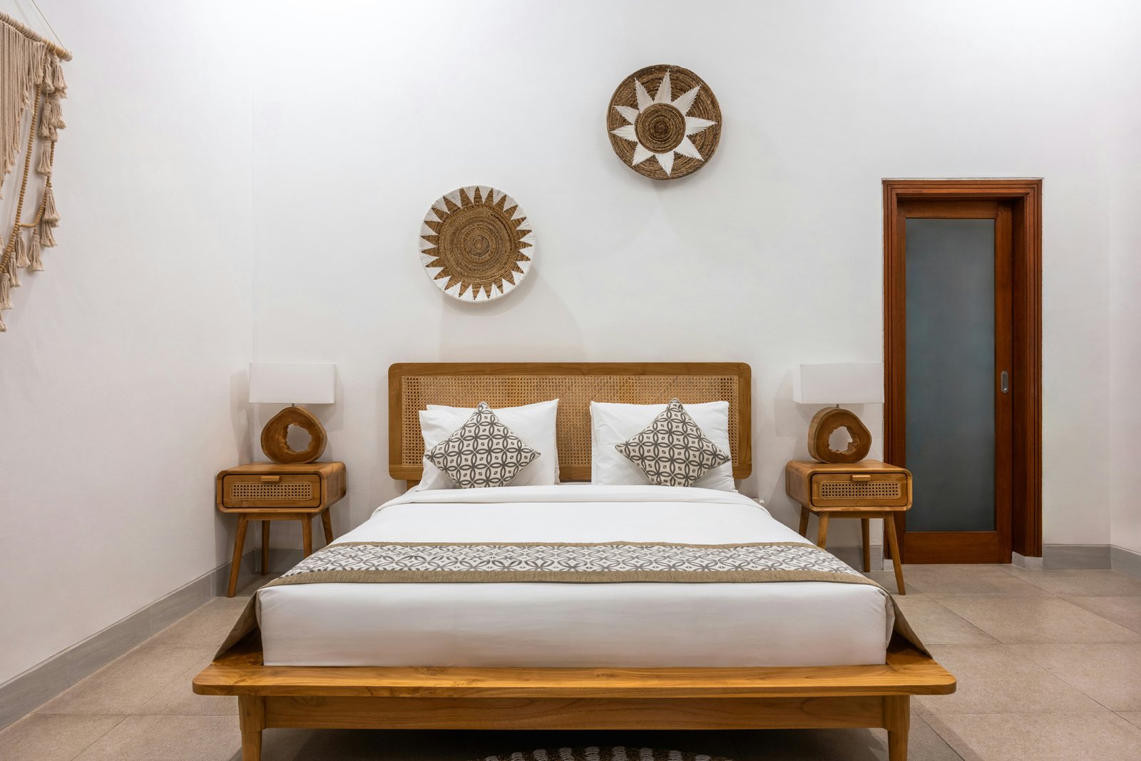 Person sitzt auf einem Bett mit Holzrahmen