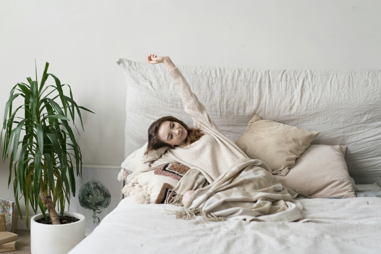 Person steht aus einem Bett im Schlafzimmer auf